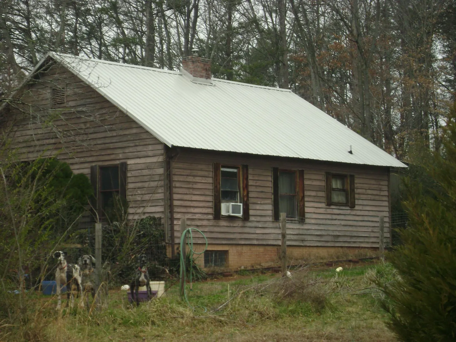White metal roof on an old wood sided farmhouse, from a Metal Roof Installation job in Holmes